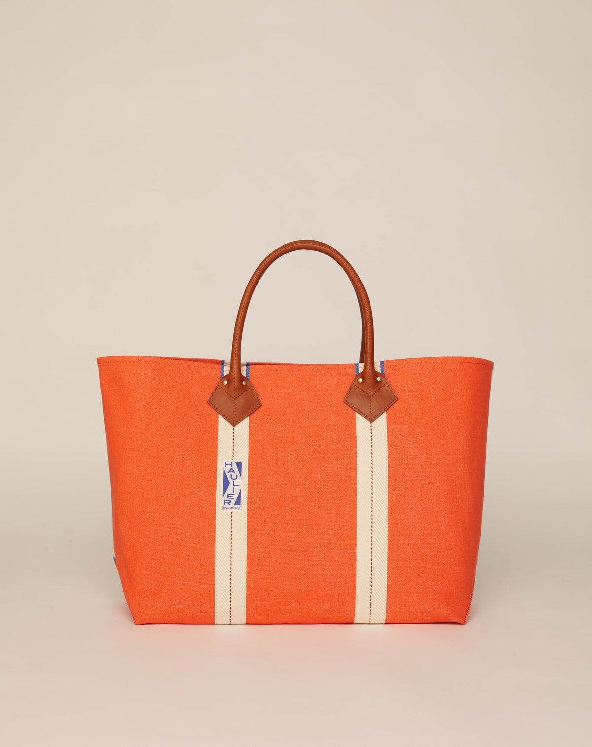 Image of classic canvas tote bag in bright orange colour with tan leather handles and contrasting natural ecru stripes.