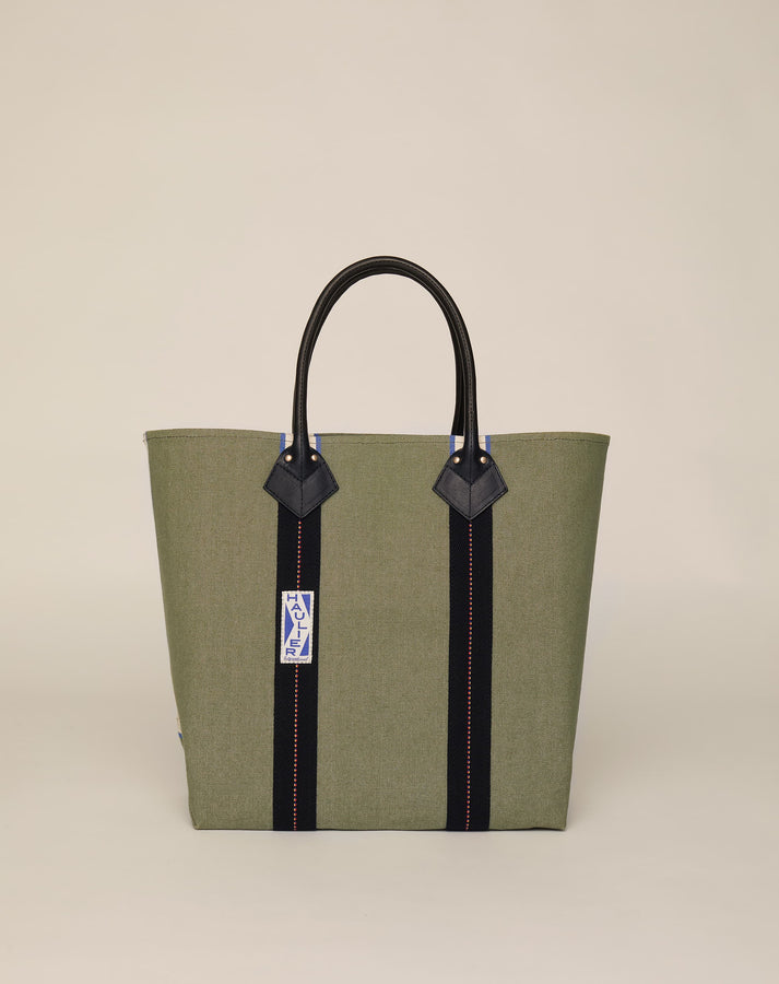 Image of medium-sized classic canvas tote bag in sage colour with black leather handles and contrasting stripes.