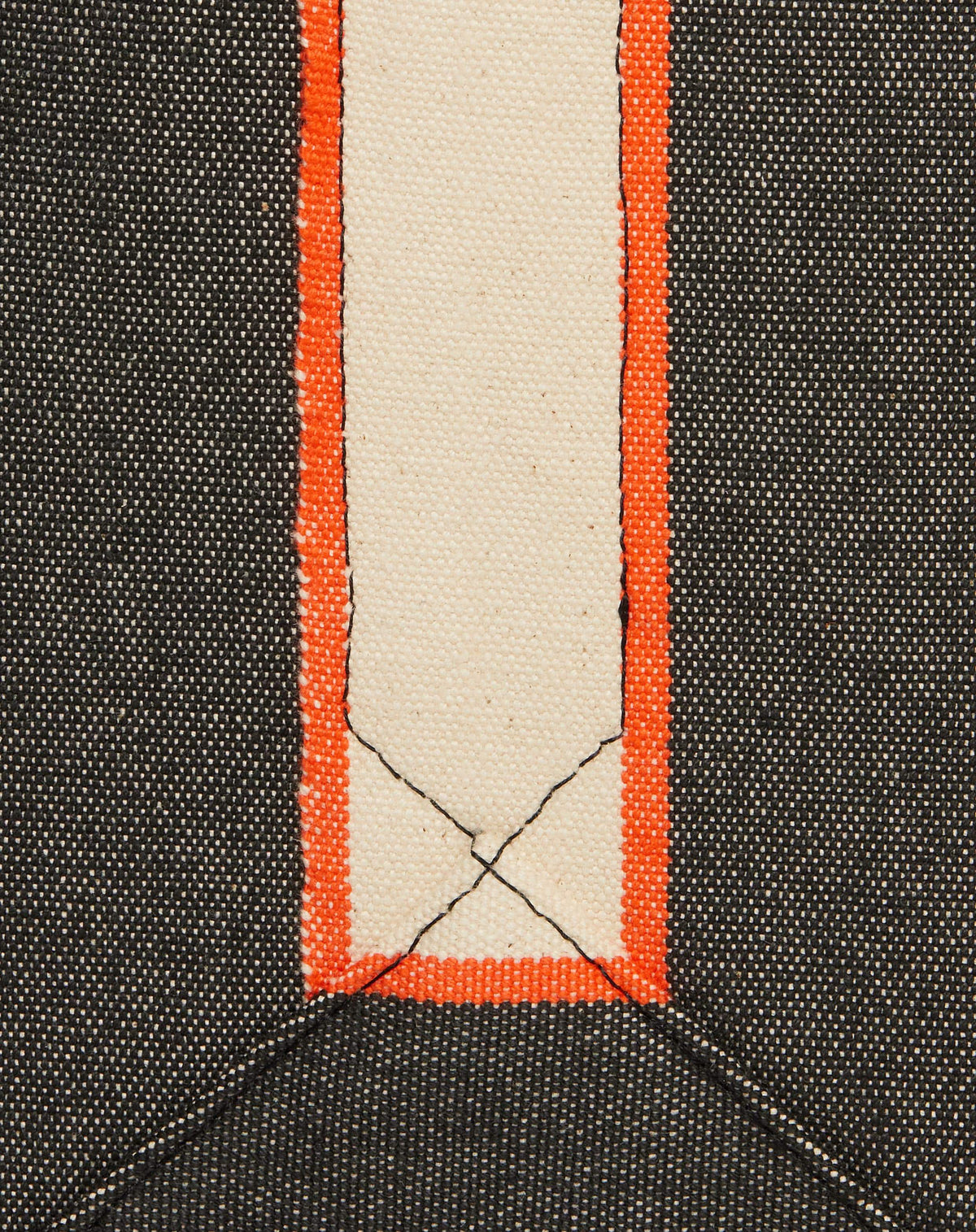 Close-up of washed black canvas with contrasting stripe and stitching detail.