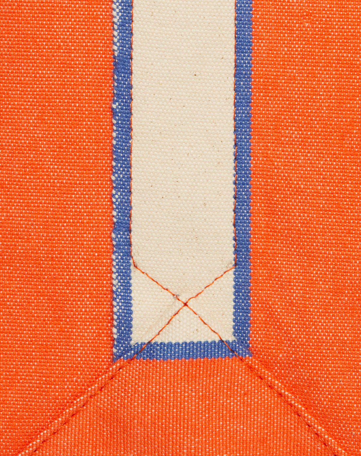 Close-up image of bright orange canvas with natural ecru stripe and orange stitching.