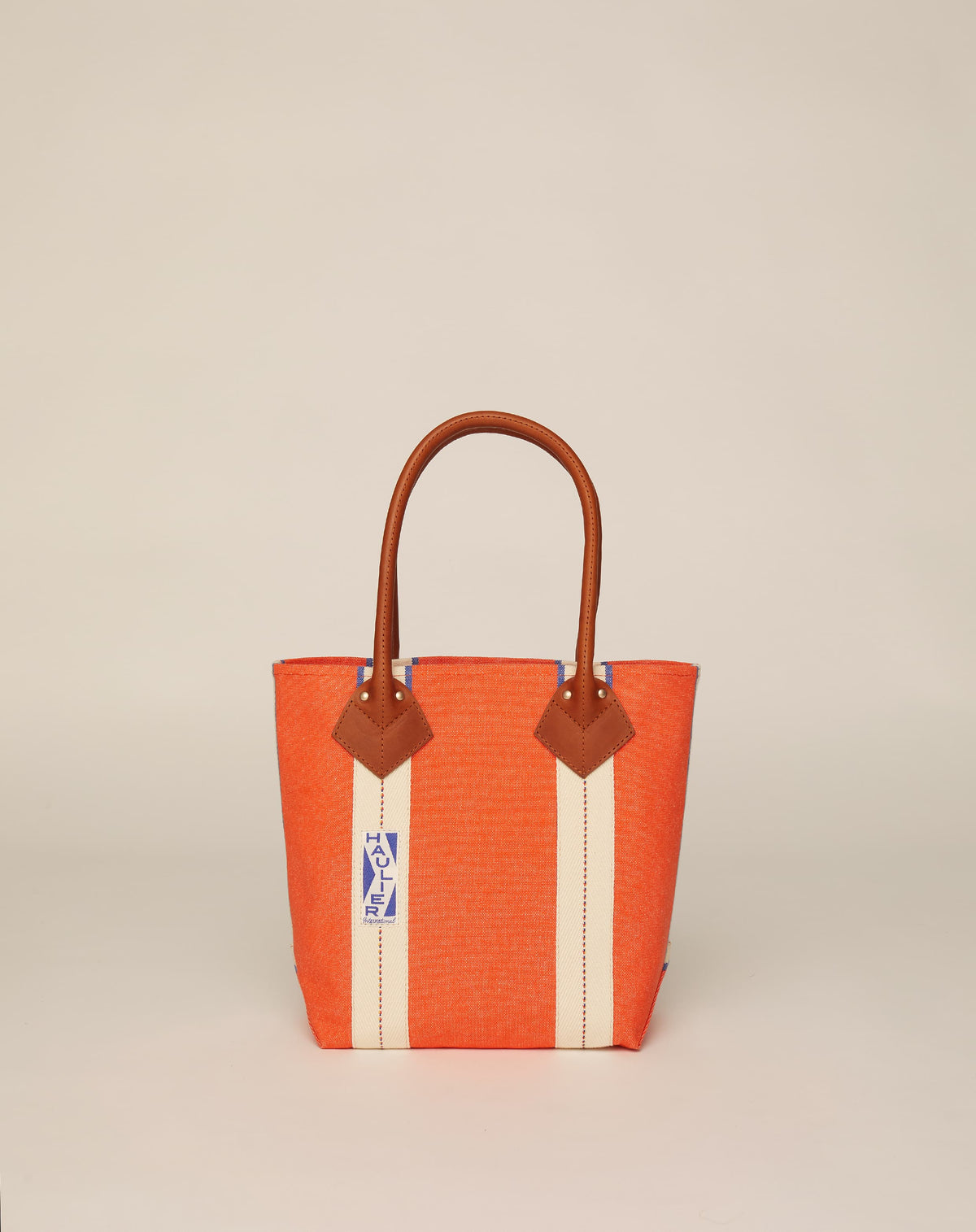 Image of small classic canvas tote bag in orange colour with tan leather handles and contrasting stripes.