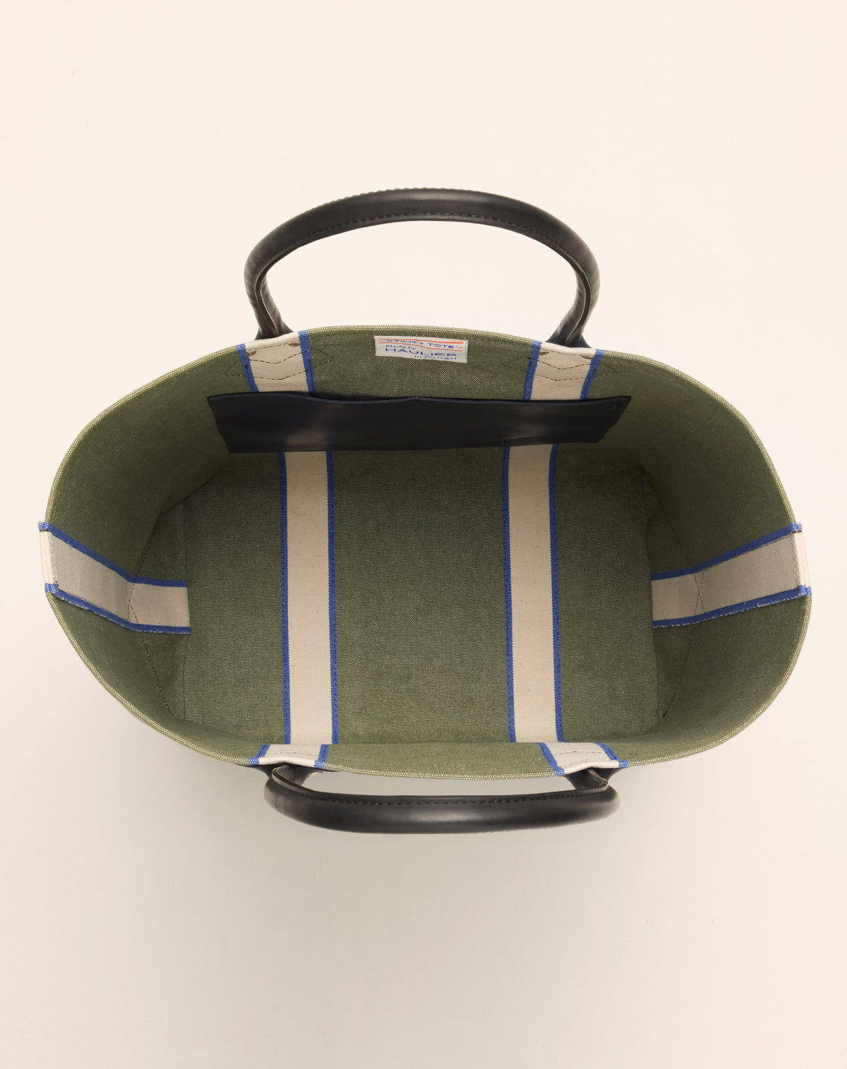 Image of inside of classic canvas tote bag in sage colour with black leather handles and contrasting natural ecru stripes.
