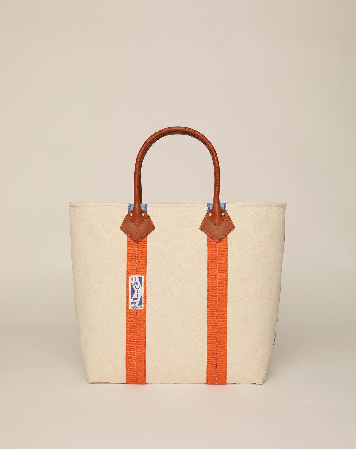 Image of medium-sized classic canvas tote bag in natural ecru colour with tan leather handles and contrasting stripes.