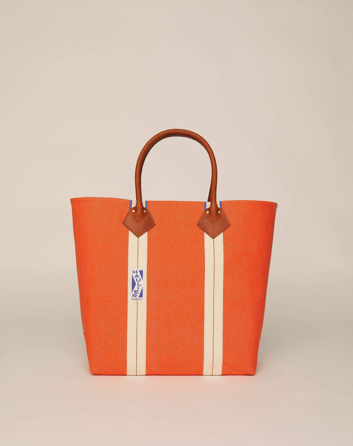 Image of medium-sized classic canvas tote bag in orange colour with tan leather handles and contrasting stripes.