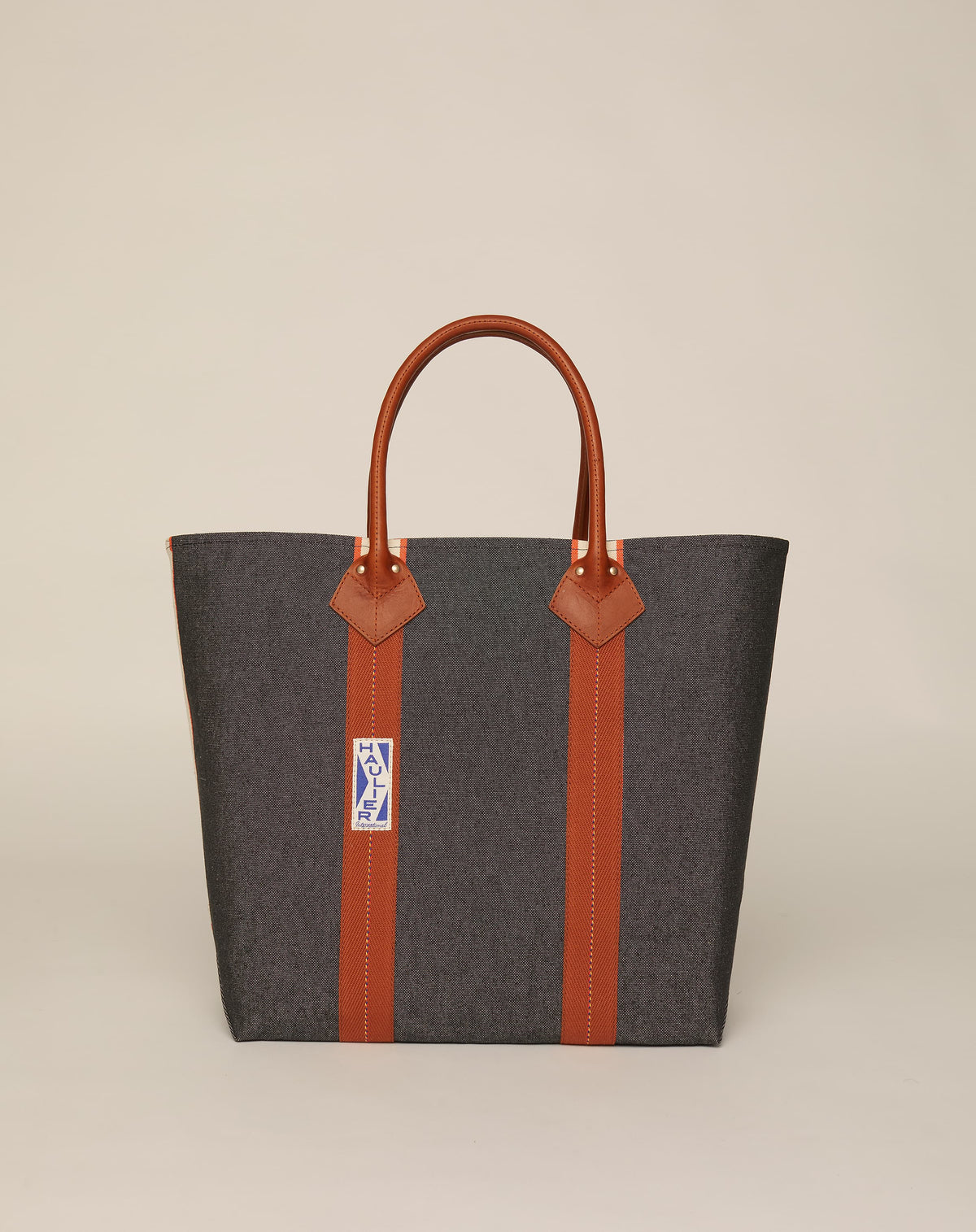 Image of medium-sized classic canvas tote bag in washed black colour with tan leather handles and contrasting stripes.
