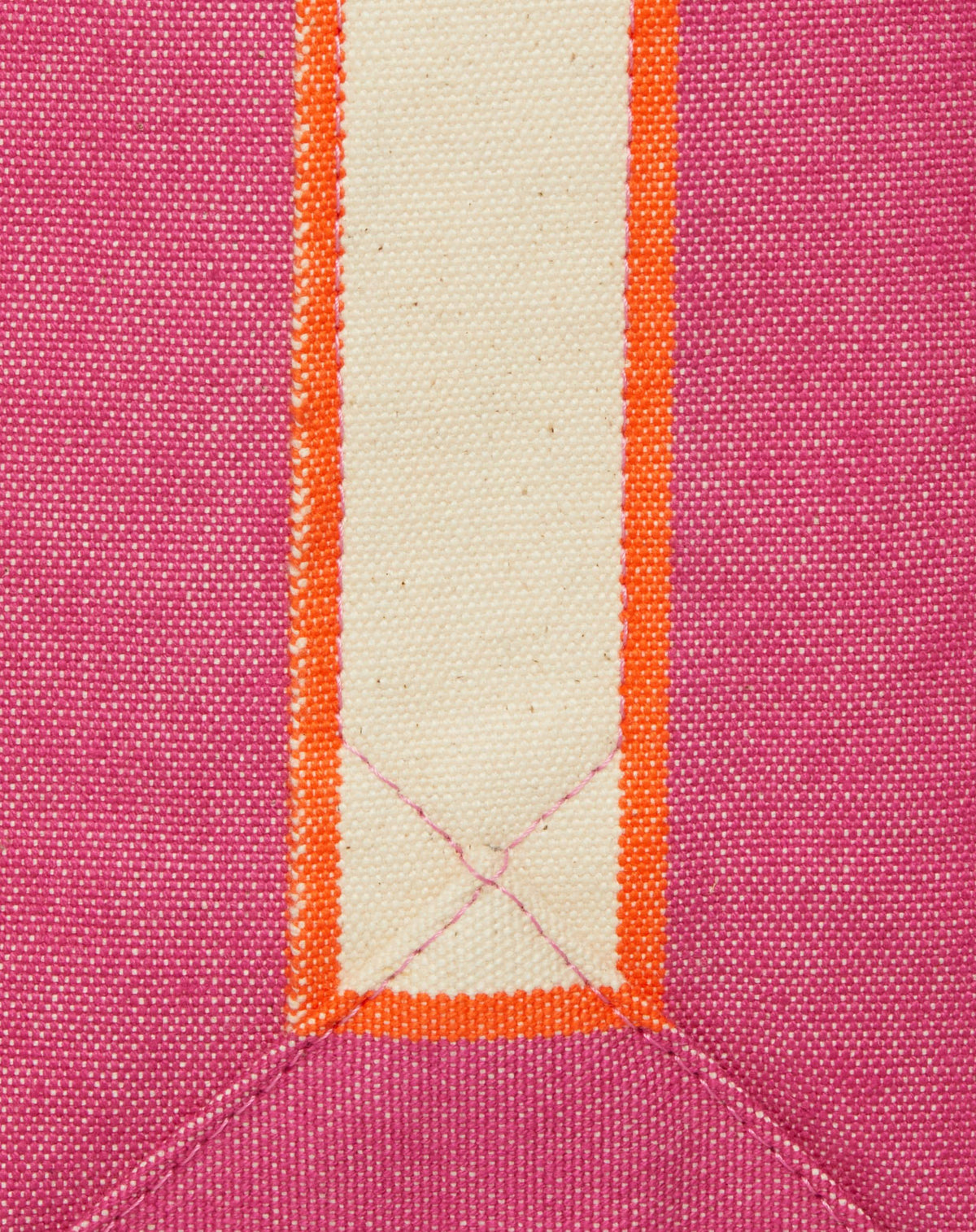 Close-up image of fuchsia canvas with contrasting stripe and stitching detail.