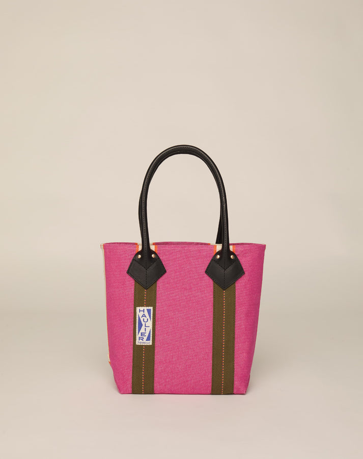 Image of small classic canvas tote bag in fuchsia colour with black leather handles and contrasting stripes.