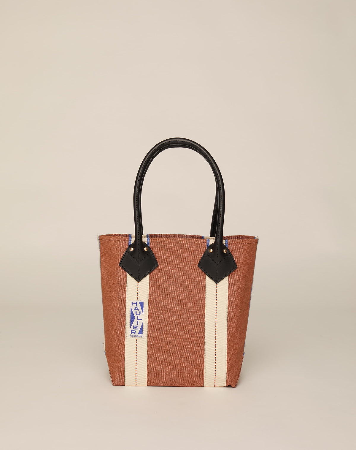 Image of small classic canvas tote bag in tan colour with black leather handles and contrasting stripes.